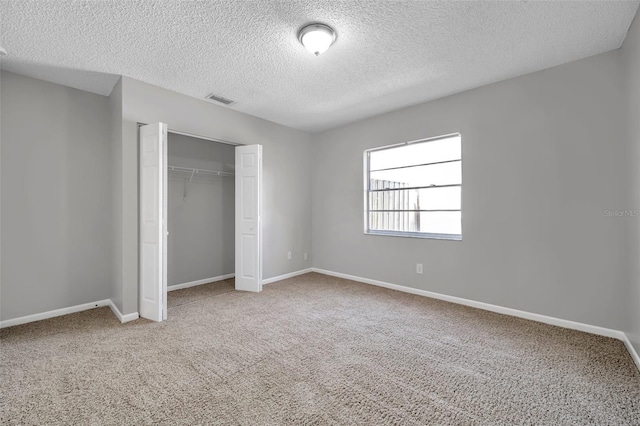 unfurnished bedroom with carpet floors, a closet, and a textured ceiling