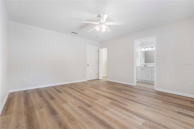 interior space with ceiling fan, ensuite bath, and light hardwood / wood-style flooring