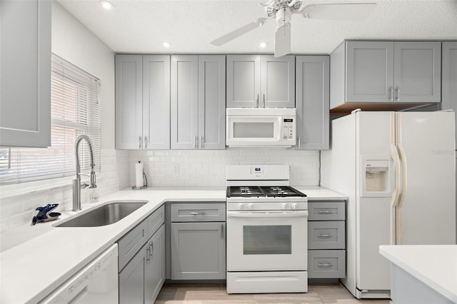 kitchen featuring white appliances, gray cabinets, sink, and decorative backsplash