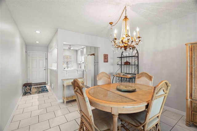 dining space featuring ceiling fan with notable chandelier, a textured ceiling, and light tile patterned flooring