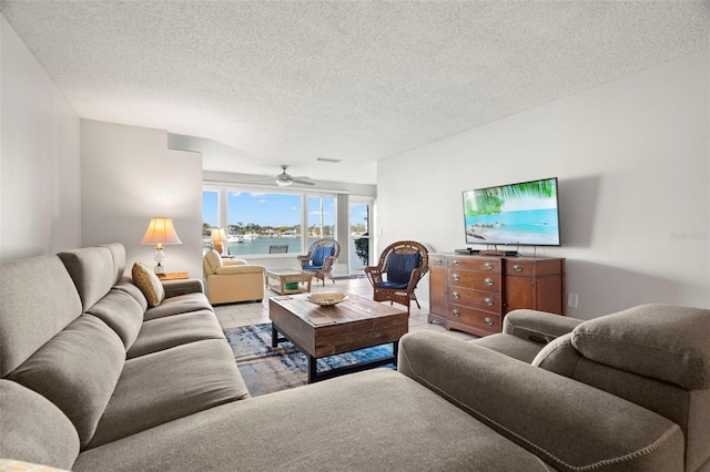 living room with ceiling fan and a textured ceiling