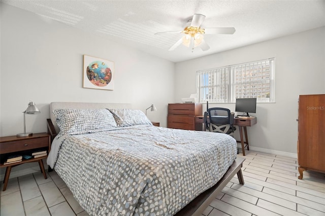 bedroom with ceiling fan and a textured ceiling