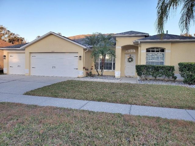 view of front of property featuring a garage and a front lawn