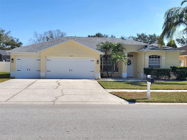 ranch-style house featuring a garage, concrete driveway, roof with shingles, stucco siding, and a front lawn