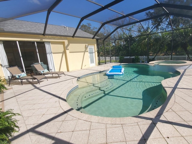 view of swimming pool with a pool with connected hot tub, a patio area, fence, and a lanai