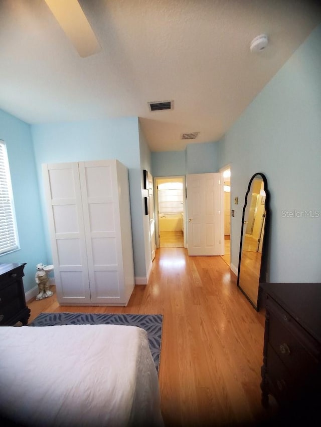 bedroom featuring baseboards, visible vents, and light wood-style floors