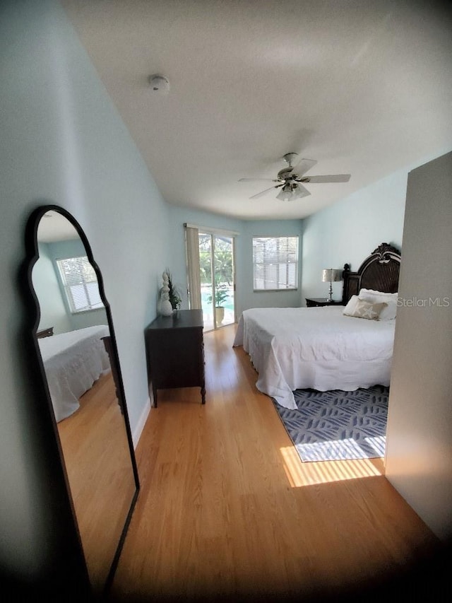 bedroom with ceiling fan, baseboards, and wood finished floors