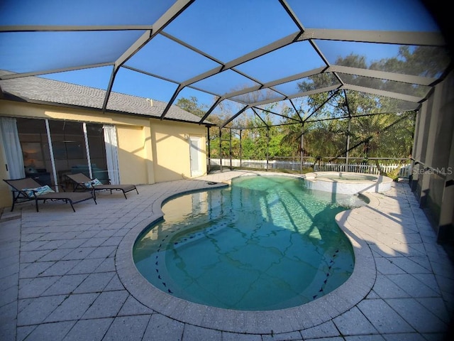 view of pool with a lanai, a patio area, and a pool with connected hot tub