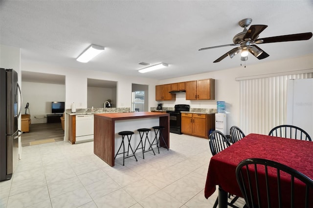 kitchen featuring sink, stainless steel fridge, electric range, white dishwasher, and a textured ceiling