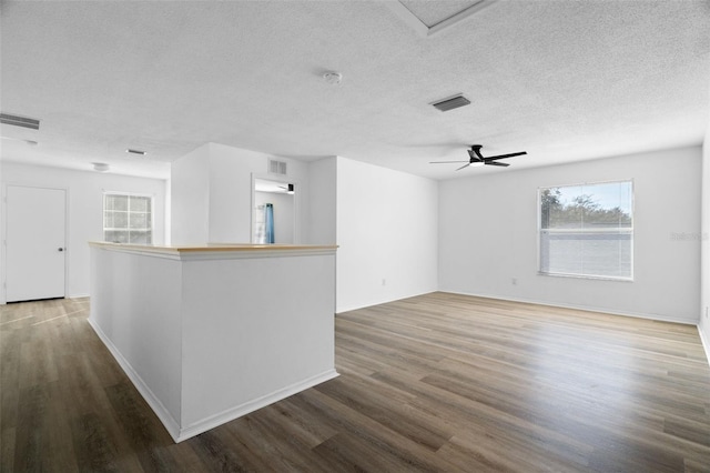 unfurnished living room with ceiling fan, hardwood / wood-style flooring, and a textured ceiling