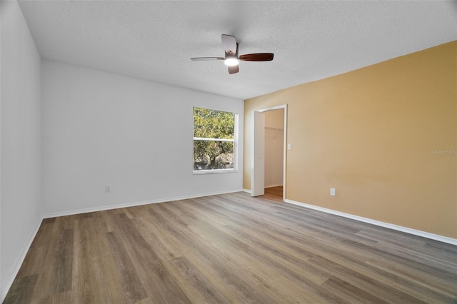 unfurnished room featuring hardwood / wood-style flooring, ceiling fan, and a textured ceiling