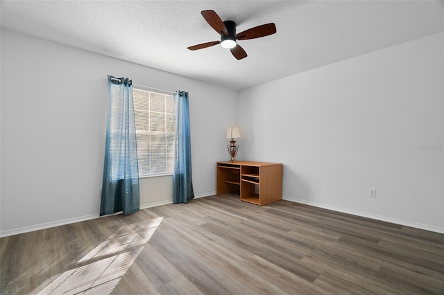 unfurnished room with wood-type flooring, ceiling fan, and a textured ceiling