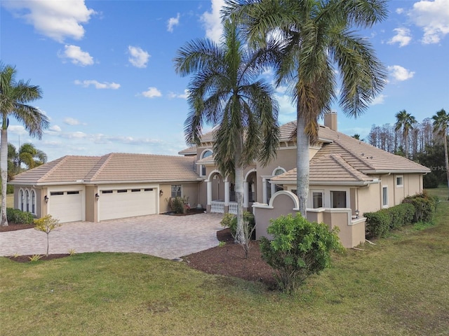 mediterranean / spanish-style home with a garage and a front yard