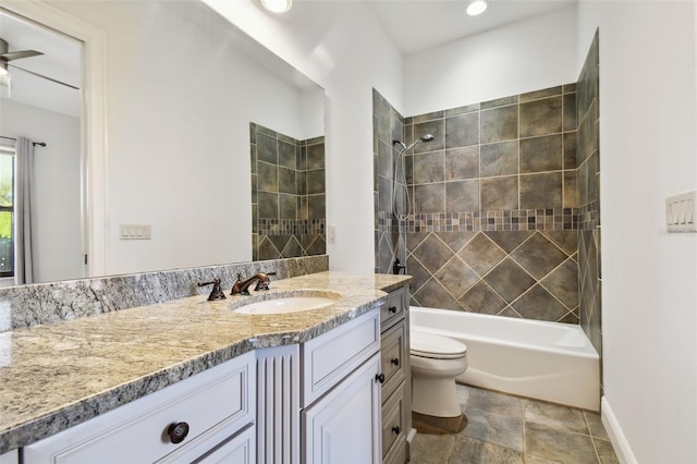 full bathroom with tiled shower / bath combo, vanity, ceiling fan, and toilet