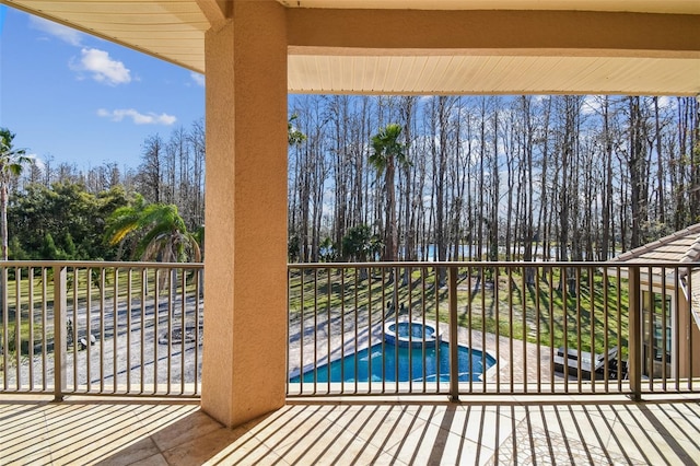 balcony with an in ground hot tub and a patio