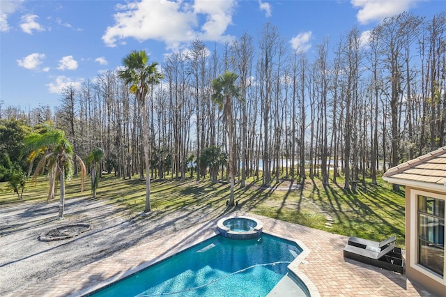 view of pool with an in ground hot tub, a lawn, and a patio