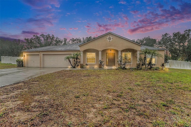 view of front of property featuring a garage and a lawn