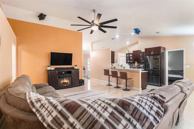 living room featuring ceiling fan and lofted ceiling