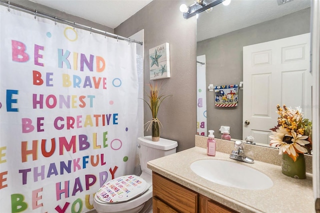 bathroom featuring a shower with curtain, vanity, and toilet