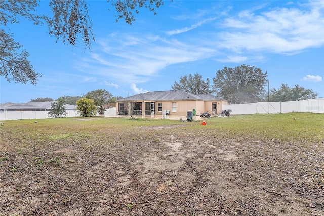 back of property with a sunroom and a yard