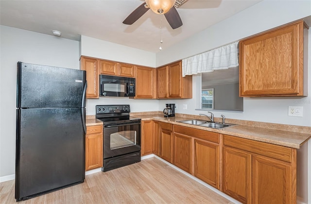 kitchen featuring ceiling fan, sink, light wood-type flooring, and black appliances