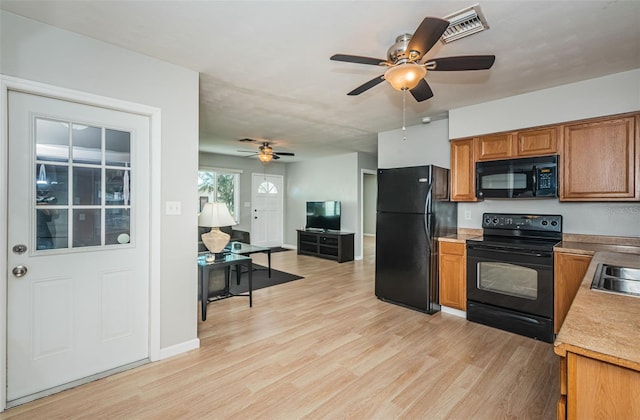 kitchen featuring sink, black appliances, light hardwood / wood-style floors, and ceiling fan