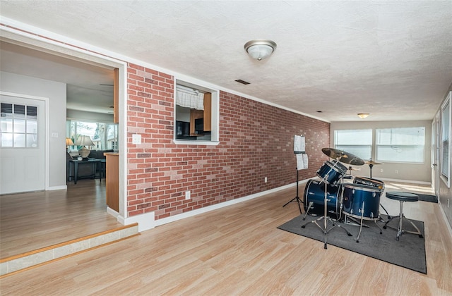 workout room with a textured ceiling and light hardwood / wood-style flooring