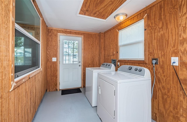 laundry room with washer and dryer and wood walls