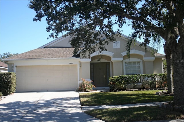 ranch-style house featuring a garage and a front lawn