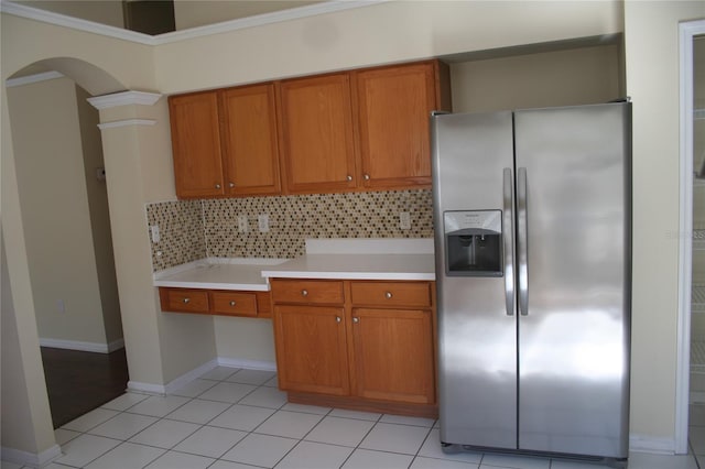 kitchen with light tile patterned floors, stainless steel fridge, and backsplash