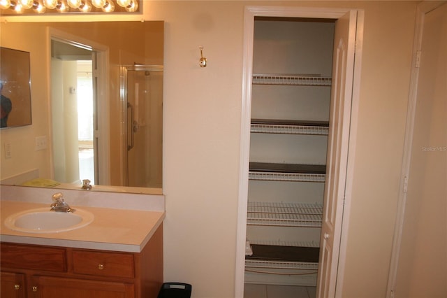 bathroom featuring walk in shower, vanity, and tile patterned flooring