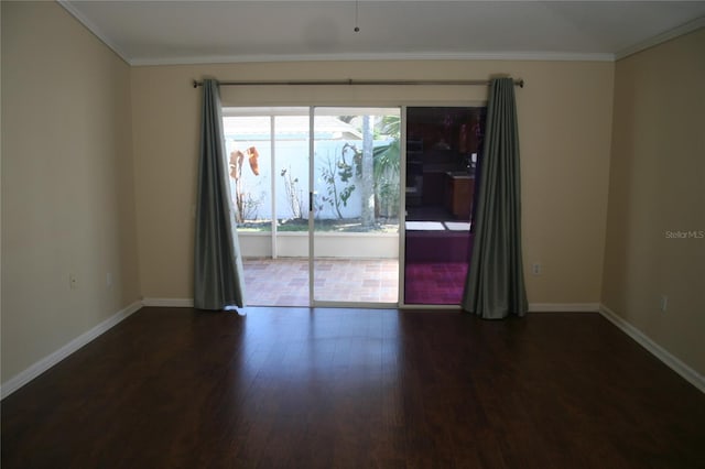 empty room featuring crown molding and dark hardwood / wood-style flooring