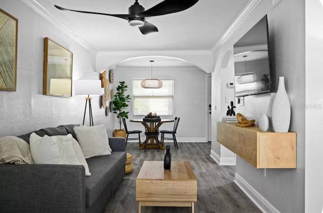 living room featuring ceiling fan, ornamental molding, and dark hardwood / wood-style floors