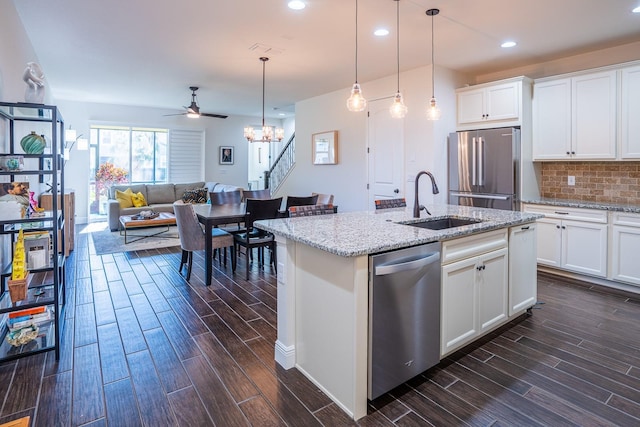 kitchen with light stone counters, sink, stainless steel appliances, and white cabinets