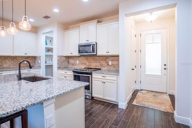 kitchen with stainless steel appliances, decorative light fixtures, sink, and white cabinets