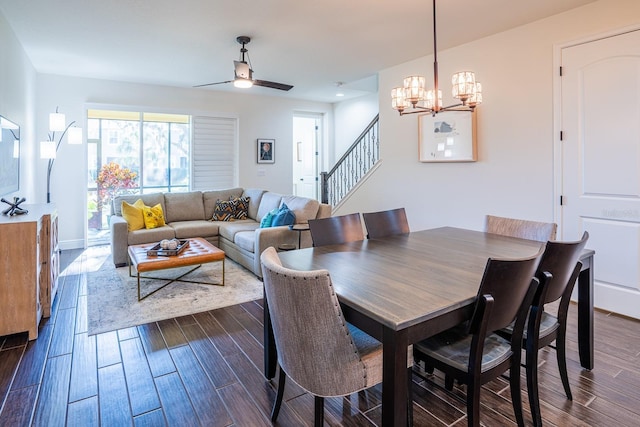 dining area with dark wood-type flooring and ceiling fan with notable chandelier