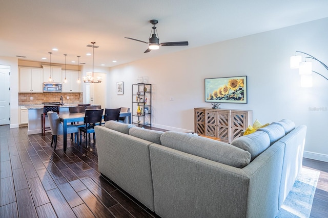 living room with ceiling fan with notable chandelier