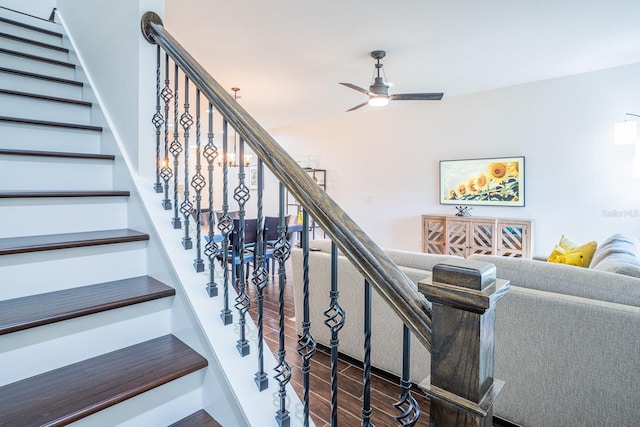 stairs with hardwood / wood-style floors and ceiling fan