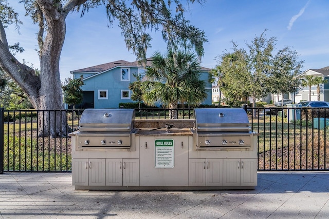 view of patio with exterior kitchen and a grill