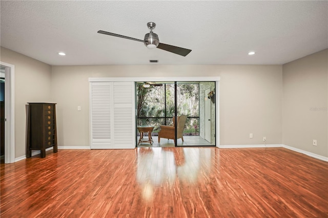 unfurnished living room with wood-type flooring, a textured ceiling, and ceiling fan