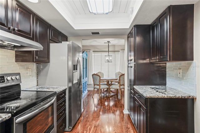 kitchen featuring crown molding, hanging light fixtures, dark hardwood / wood-style flooring, a raised ceiling, and stainless steel electric stove