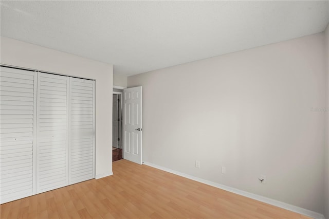 unfurnished bedroom featuring wood-type flooring and a closet