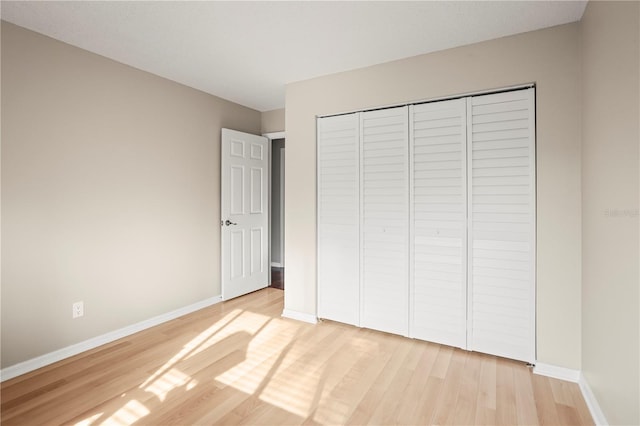 unfurnished bedroom with light hardwood / wood-style floors and a closet