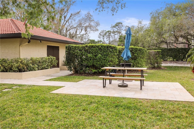 view of home's community featuring a patio area and a lawn