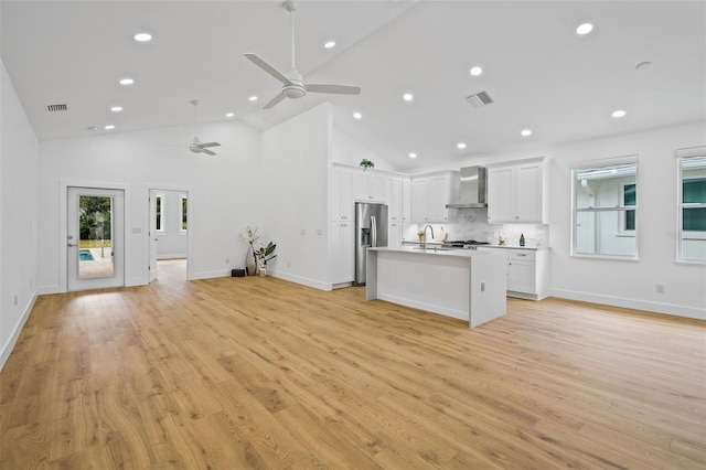 unfurnished living room featuring sink, high vaulted ceiling, light hardwood / wood-style floors, and ceiling fan