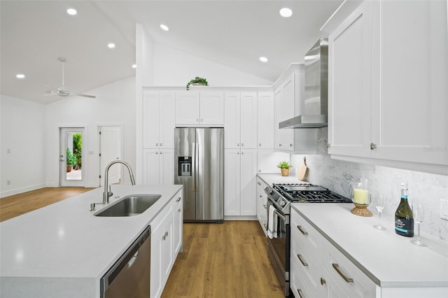 kitchen featuring appliances with stainless steel finishes, sink, white cabinets, and wall chimney exhaust hood