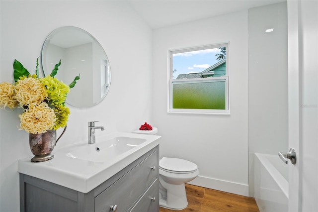 bathroom with vanity, a bathtub, wood-type flooring, and toilet