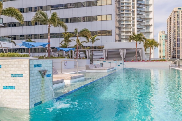 view of swimming pool with pool water feature