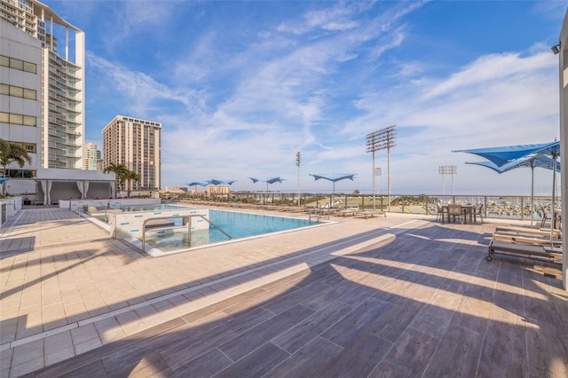 view of pool featuring a jacuzzi and a patio