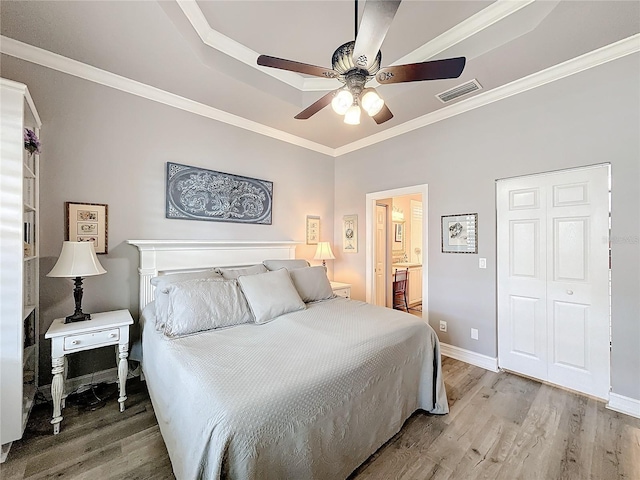 bedroom with ceiling fan, ornamental molding, ensuite bathroom, and hardwood / wood-style floors